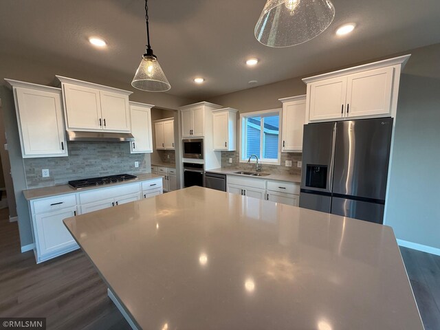 kitchen featuring pendant lighting, dark hardwood / wood-style floors, white cabinetry, and appliances with stainless steel finishes