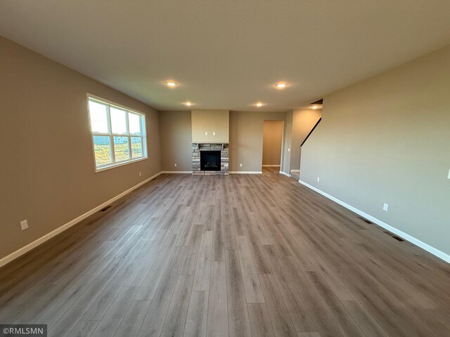 unfurnished living room featuring a fireplace and light hardwood / wood-style floors