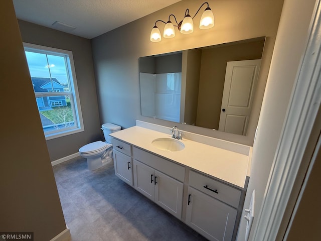 bathroom featuring vanity, toilet, and a textured ceiling