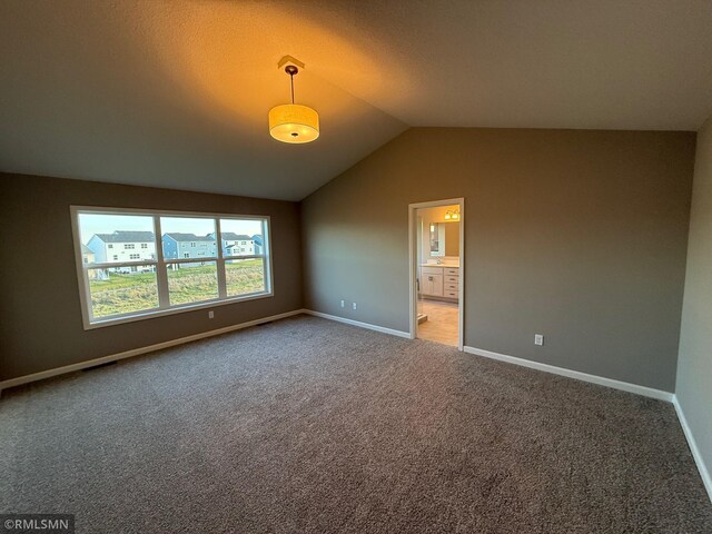 spare room with carpet and lofted ceiling