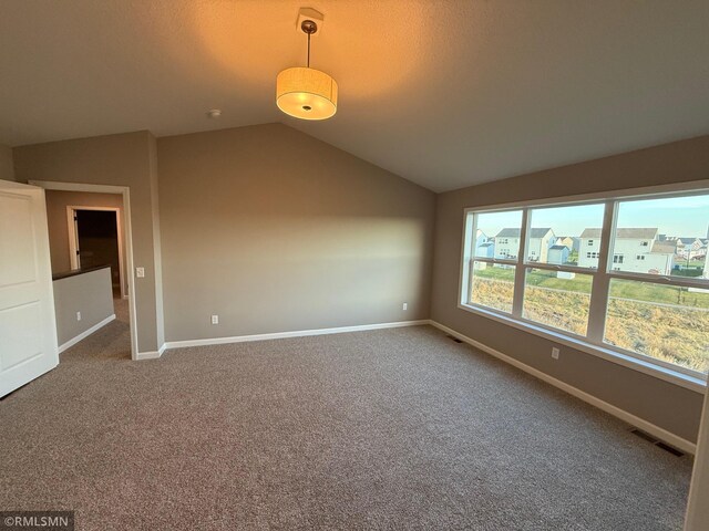 carpeted empty room featuring lofted ceiling