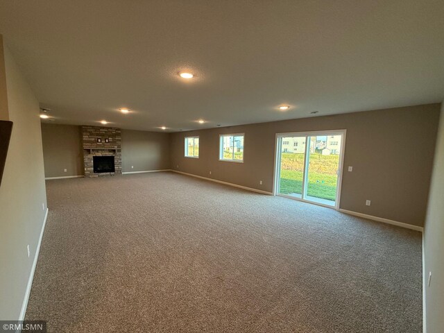 unfurnished living room with a fireplace and carpet floors