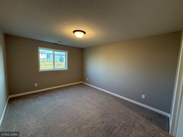 carpeted spare room with a textured ceiling