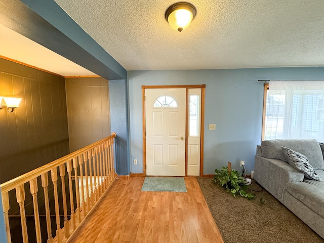 foyer with a wealth of natural light, wood-type flooring, and a textured ceiling