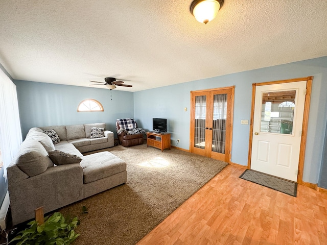 living room featuring a textured ceiling, hardwood / wood-style flooring, plenty of natural light, and ceiling fan