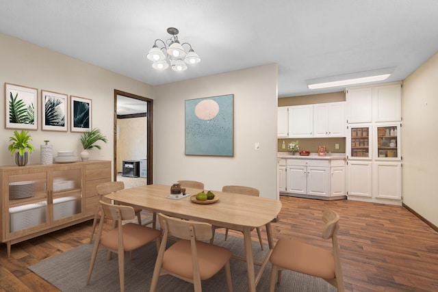 dining area with a notable chandelier and dark hardwood / wood-style floors