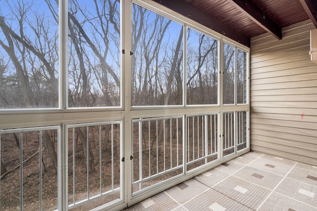 unfurnished sunroom with beamed ceiling and wooden ceiling