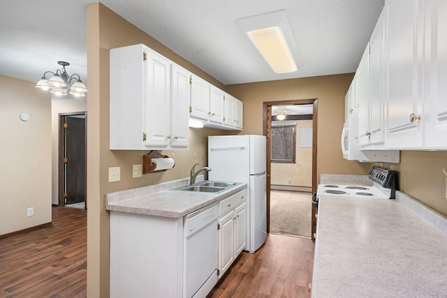 kitchen featuring sink, a chandelier, pendant lighting, white appliances, and white cabinets