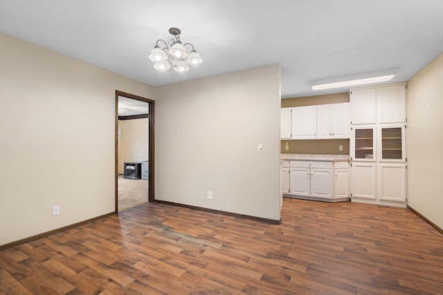 interior space featuring white cabinetry, dark hardwood / wood-style flooring, hanging light fixtures, and a notable chandelier