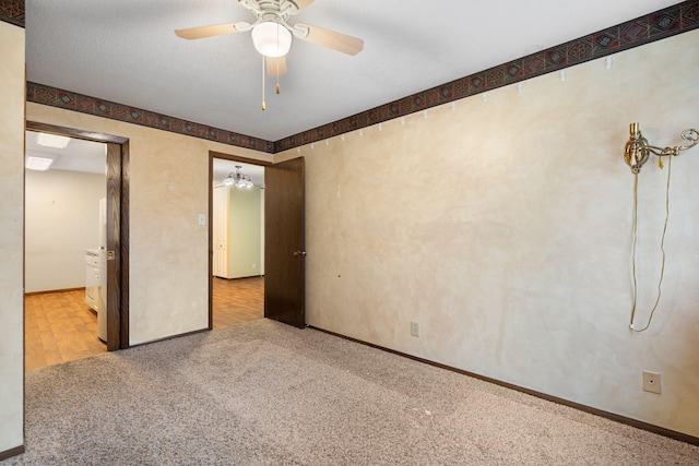 unfurnished bedroom with ceiling fan, light colored carpet, and a textured ceiling