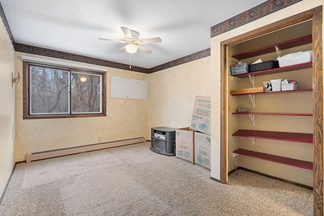 interior space featuring ceiling fan, a textured ceiling, and a baseboard heating unit