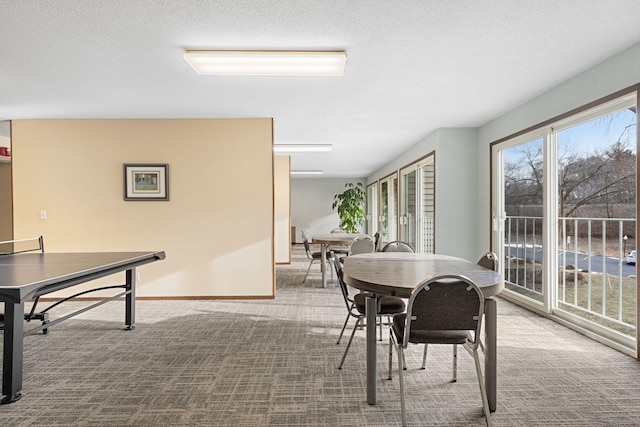 dining space featuring carpet flooring and a textured ceiling