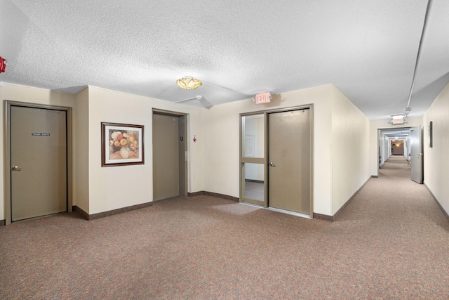 unfurnished room featuring a textured ceiling and elevator