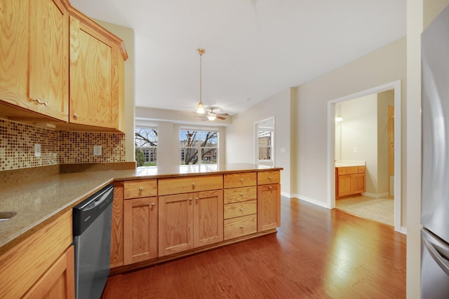 kitchen featuring decorative backsplash, kitchen peninsula, stainless steel appliances, ceiling fan, and hardwood / wood-style flooring