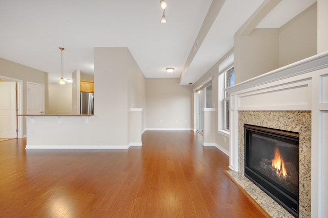 unfurnished living room featuring wood-type flooring and a premium fireplace