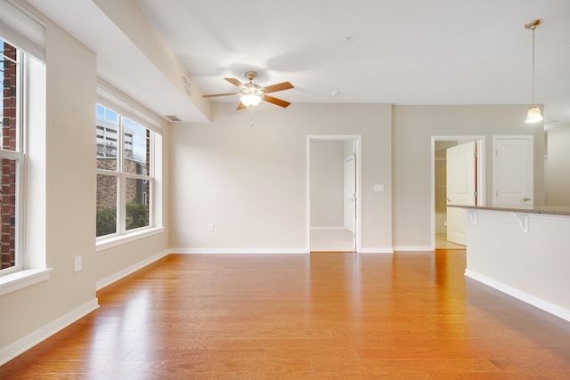 unfurnished living room with light hardwood / wood-style floors and ceiling fan