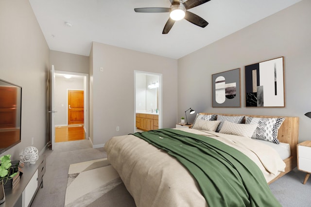 bedroom with ensuite bath, ceiling fan, and light colored carpet