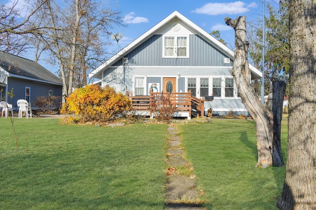 view of front facade with a front yard and a wooden deck