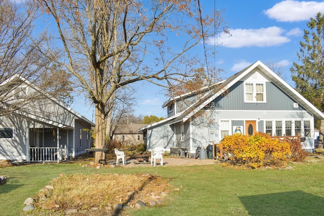 view of side of property with a fire pit and a yard