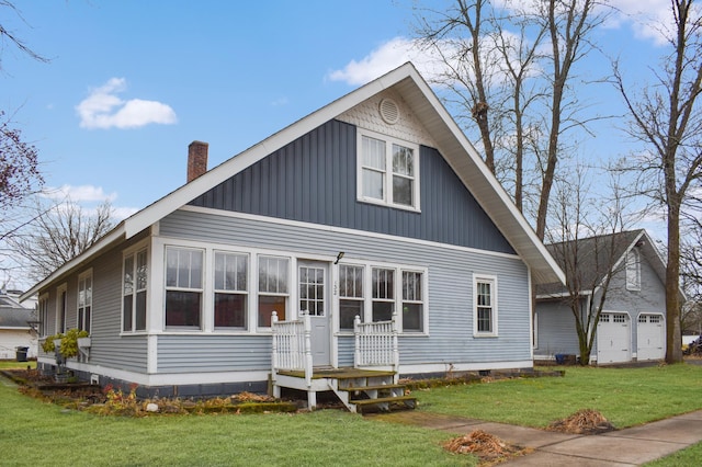 back of property featuring a garage and a yard