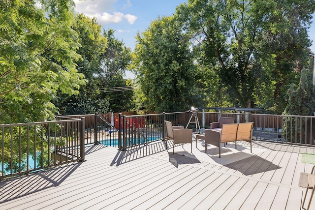 wooden deck with a fenced in pool and fence