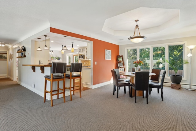 dining area featuring a tray ceiling, baseboards, and carpet