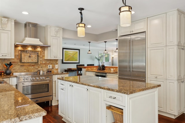 kitchen featuring backsplash, a center island, dark wood finished floors, stainless steel appliances, and wall chimney exhaust hood