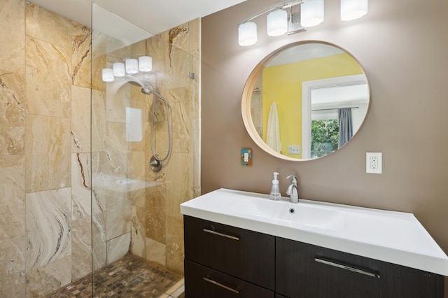 full bath featuring tiled shower and vanity