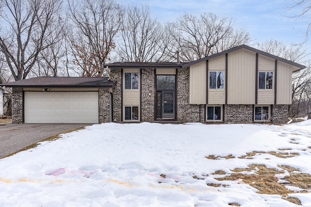 view of front of house featuring an attached garage, brick siding, and driveway