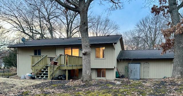 back of house featuring stairs and a wooden deck