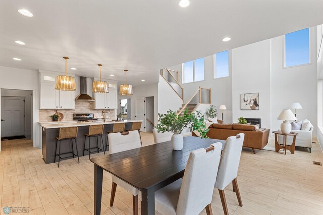 dining room with plenty of natural light, sink, and light hardwood / wood-style flooring