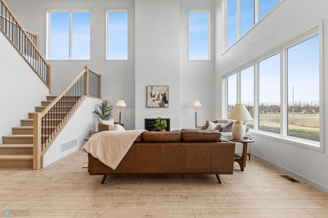 living room with light hardwood / wood-style flooring and a high ceiling