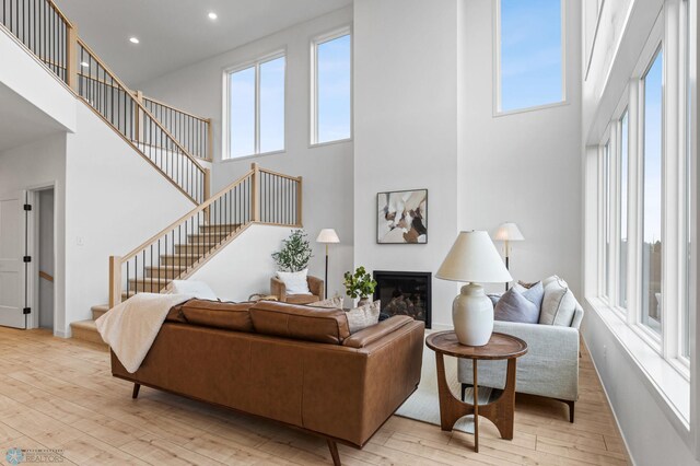 living room featuring light wood-type flooring and a high ceiling