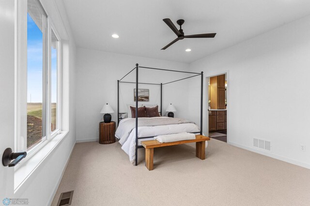 bedroom with carpet flooring, ensuite bathroom, and ceiling fan