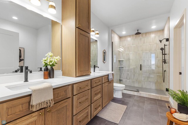 bathroom featuring tile patterned flooring, vanity, toilet, and a shower with door