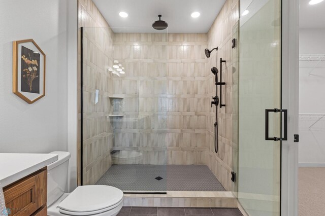 bathroom featuring tile patterned floors, vanity, toilet, and walk in shower