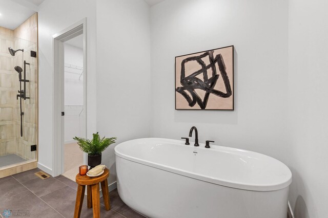 bathroom with tile patterned floors and shower with separate bathtub