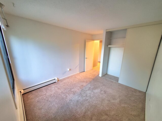 4110 Rahn Rd Unit 215, Eagan, MN 55122 - unfurnished bedroom featuring a baseboard heating unit, carpet flooring, and a closet