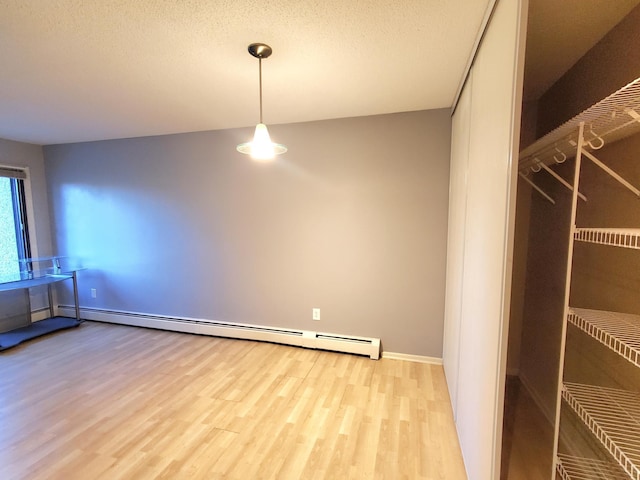 4110 Rahn Rd Unit 215, Eagan, MN 55122 - unfurnished dining area featuring a baseboard radiator, light wood-style floors, and a textured ceiling
