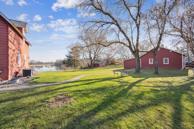 view of yard with central AC unit and a water view