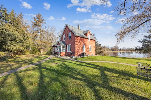 view of property exterior featuring cooling unit, a water view, and a yard