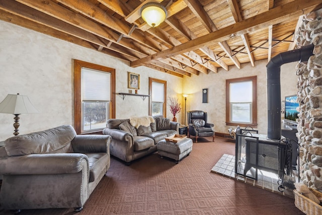 living room featuring beam ceiling, a wood stove, and wooden ceiling