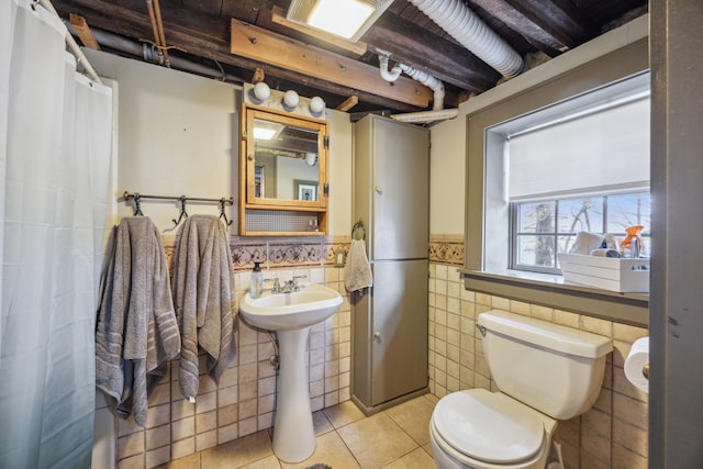 bathroom featuring sink, tile patterned flooring, tile walls, and toilet