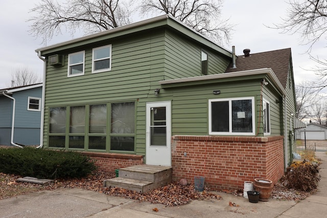 back of house with a wall mounted air conditioner