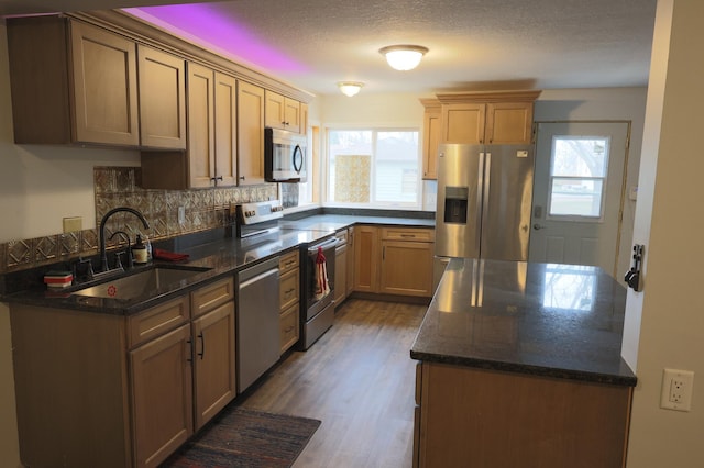 kitchen featuring appliances with stainless steel finishes, dark hardwood / wood-style floors, plenty of natural light, and sink