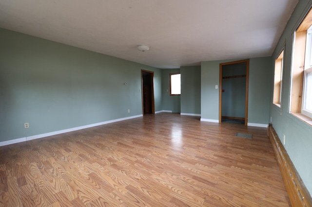 unfurnished room with light wood-type flooring and a wealth of natural light