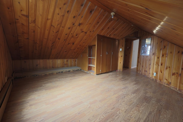 bonus room featuring a baseboard radiator, light hardwood / wood-style flooring, wood walls, vaulted ceiling, and wood ceiling