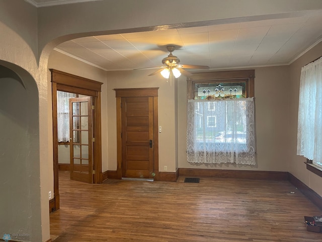 unfurnished dining area featuring ceiling fan, wood-type flooring, and crown molding