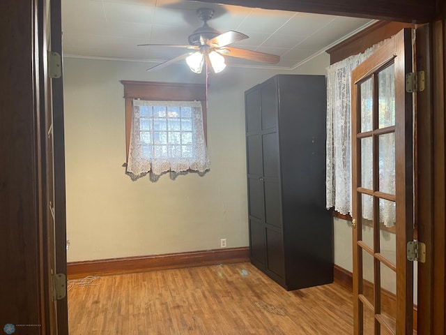 spare room with ceiling fan, a healthy amount of sunlight, light wood-type flooring, and ornamental molding