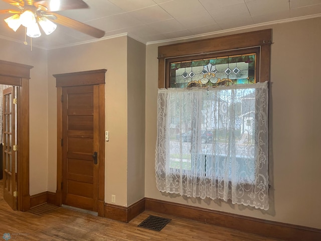 interior space with hardwood / wood-style floors, ceiling fan, and crown molding